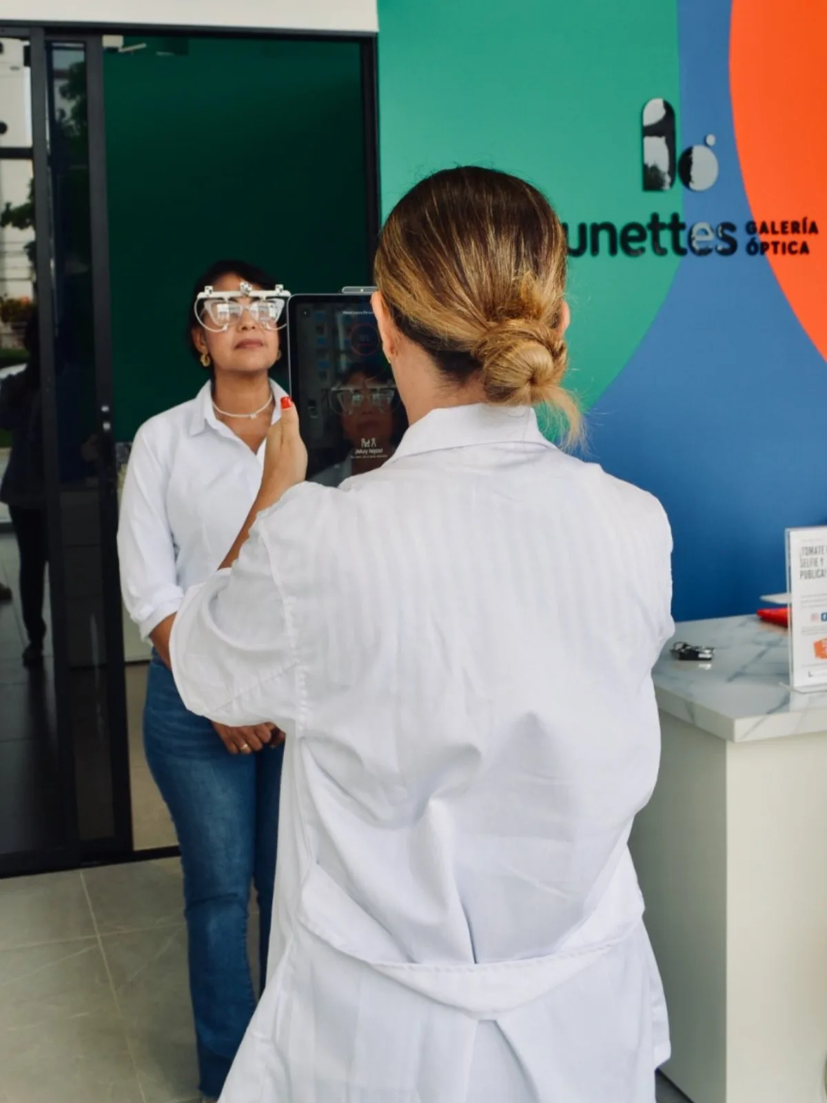 Asesora Lunettes atendiendo a una clienta con equipo de escaneo facial